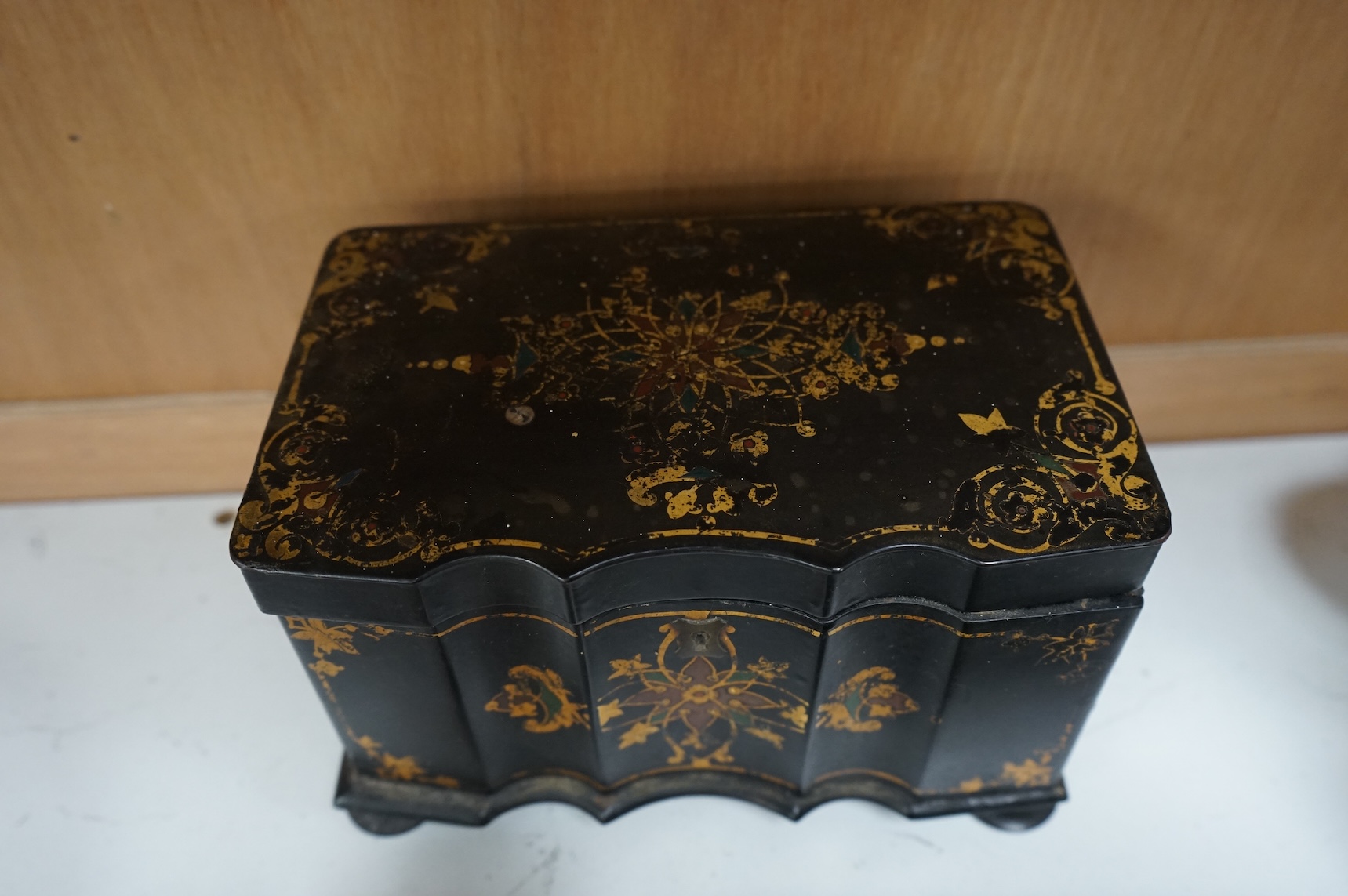 A Victorian papier maché tea caddy, postal scales and a military interest cigarette box, largest 19cm wide
